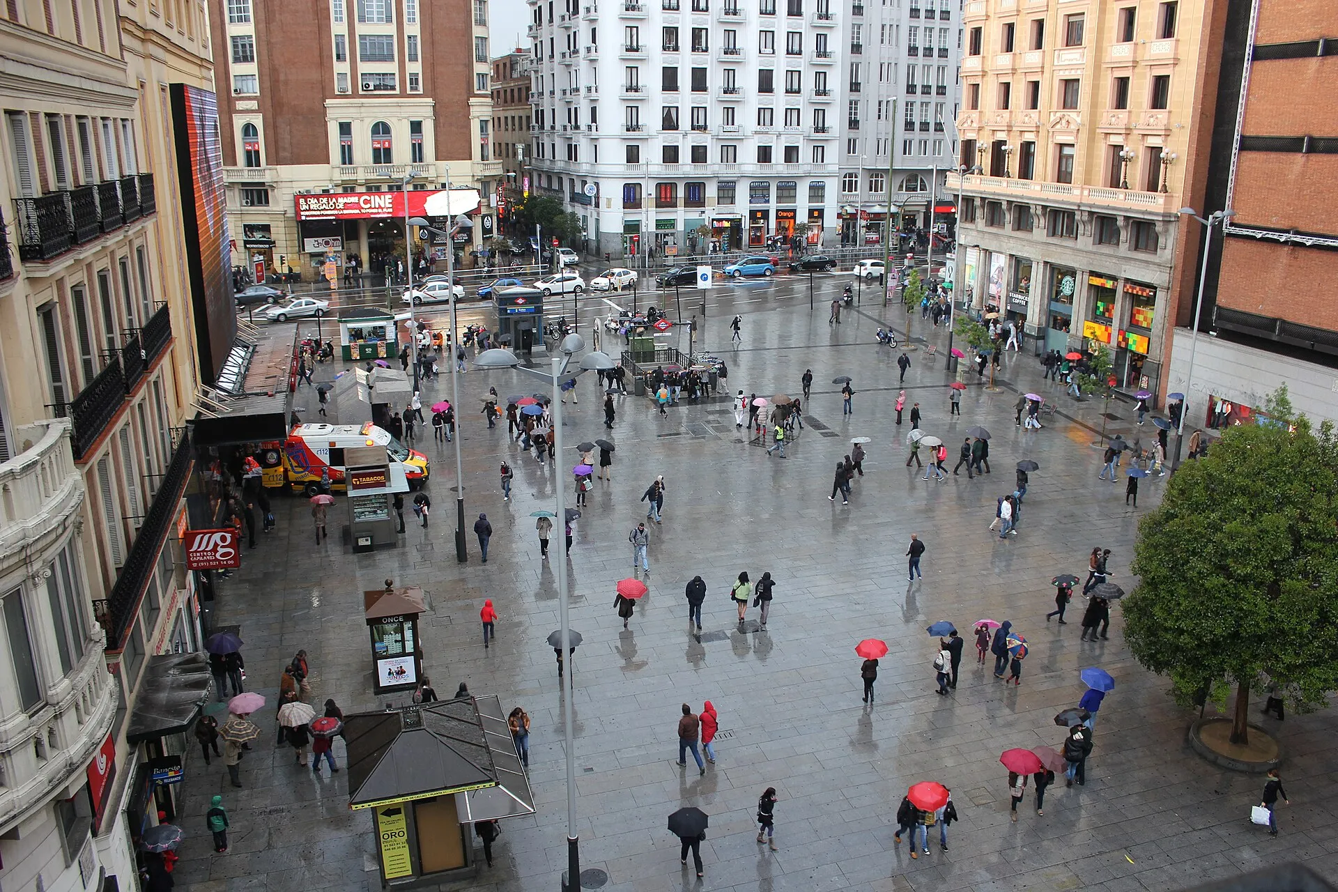 La plaza de Callao un día de lluvia, llena de gente con paraguas