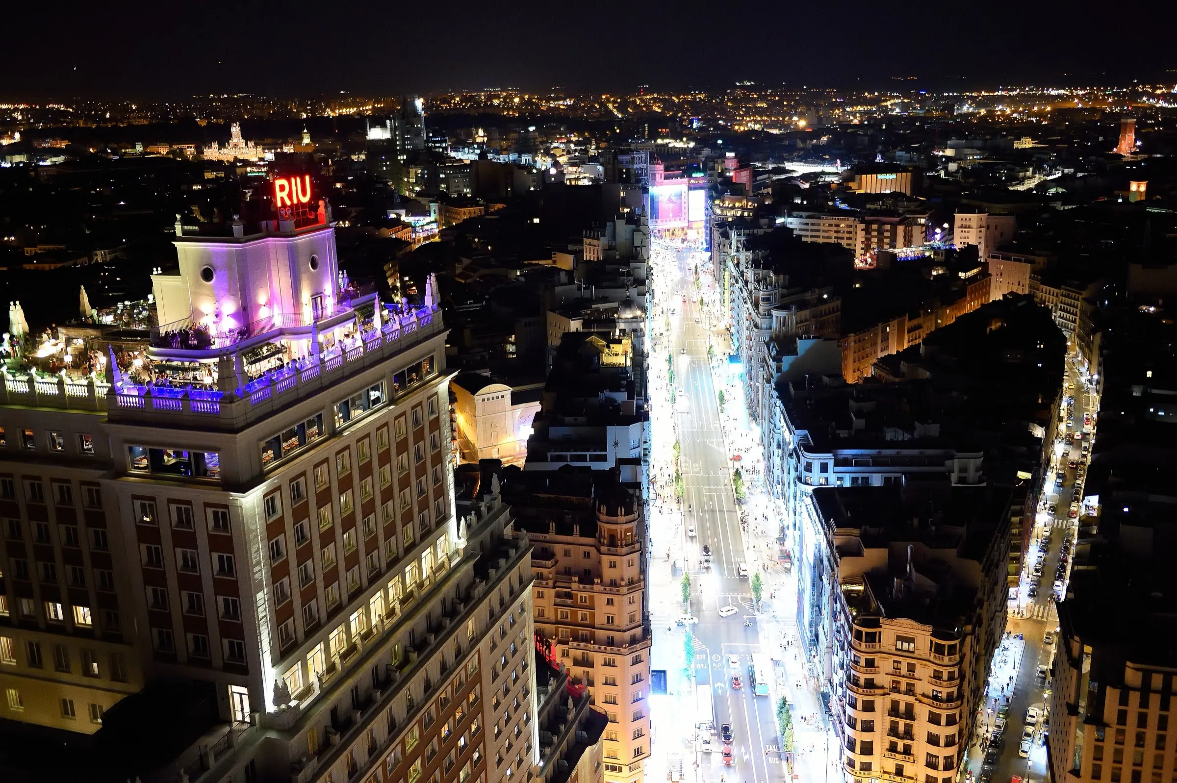 La Gran Vía de noche, con el tráfico y los edificios iluminados